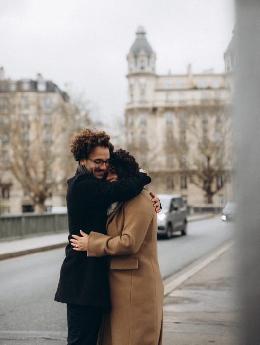 Intimate couple embrace in Paris streets, lifestyle photography session near Haussmann buildings