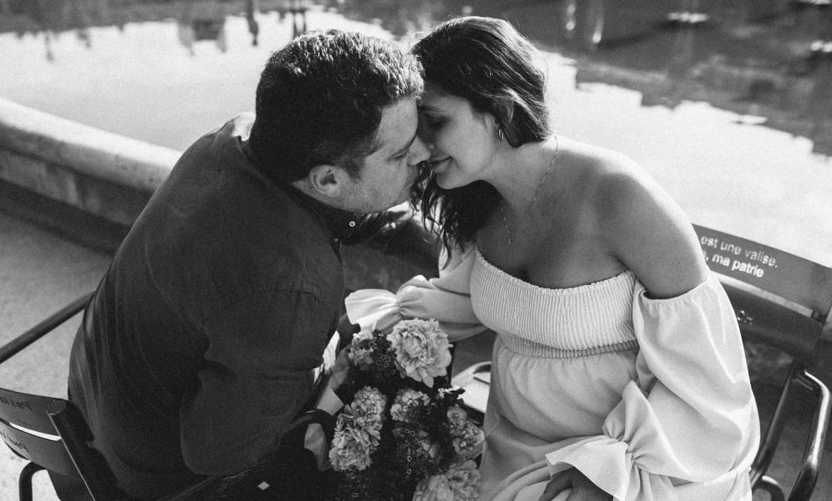Black and white romantic couple portrait with bouquet, Seine River Paris photoshoot
