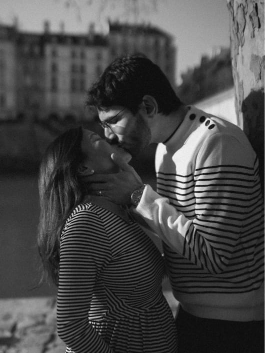 Black and white intimate portrait of couple in striped outfits, Seine river Paris engagement session