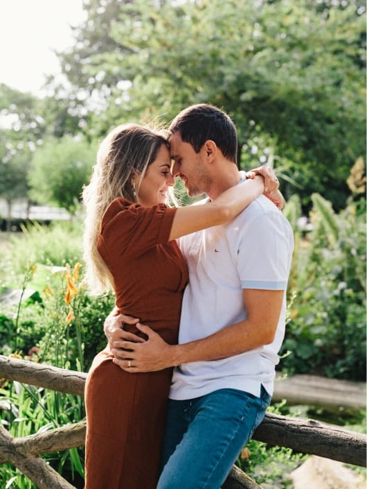 Natural light portrait of couple embracing in Parisian garden, romantic outdoor engagement photography