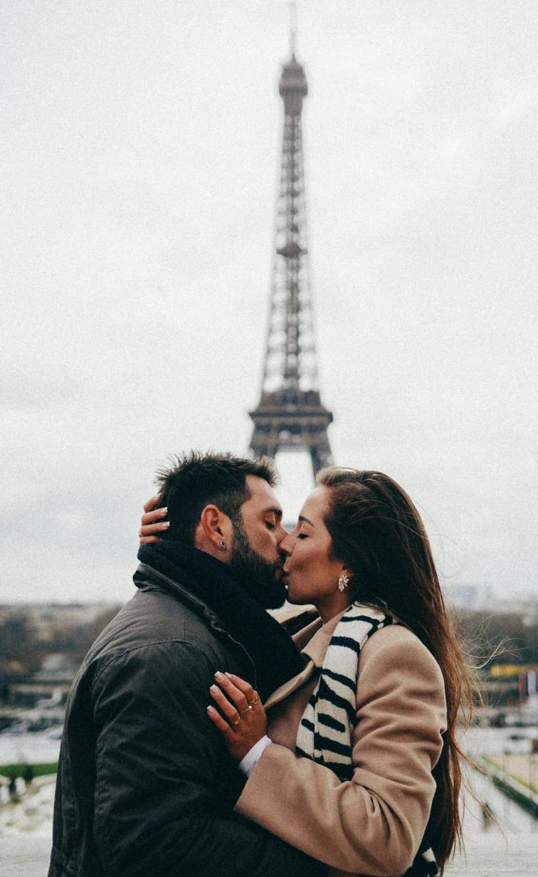 Couple kissing in Paris with the Eiffel Tower in the background