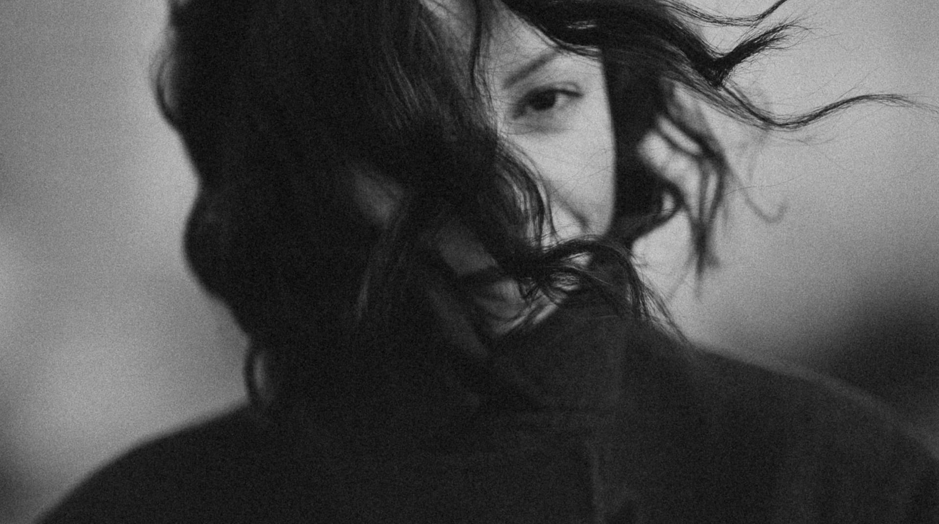 Close-up photo of a woman in Paris with wind-blown hair covering part of her face 1
