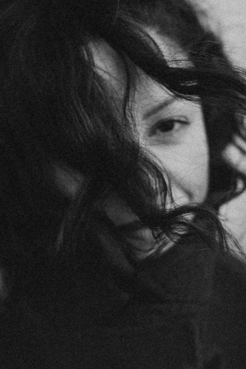 Close-up photo of a woman in Paris with wind-blown hair covering part of her face 1