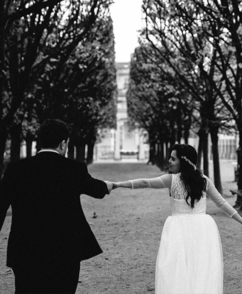 Wedding photo in Paris of a bride holding her bouquet and her groom by the hand