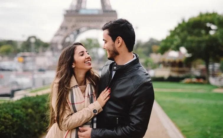 Playful couple portrait in Montmartre cobblestone streets, candid Paris photography session