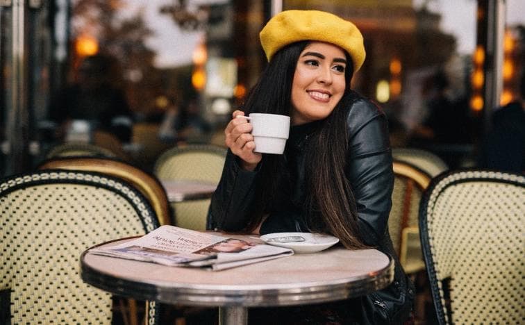Two friends laughing by the Seine river with Eiffel Tower view, candid lifestyle portrait in Paris with boats in background