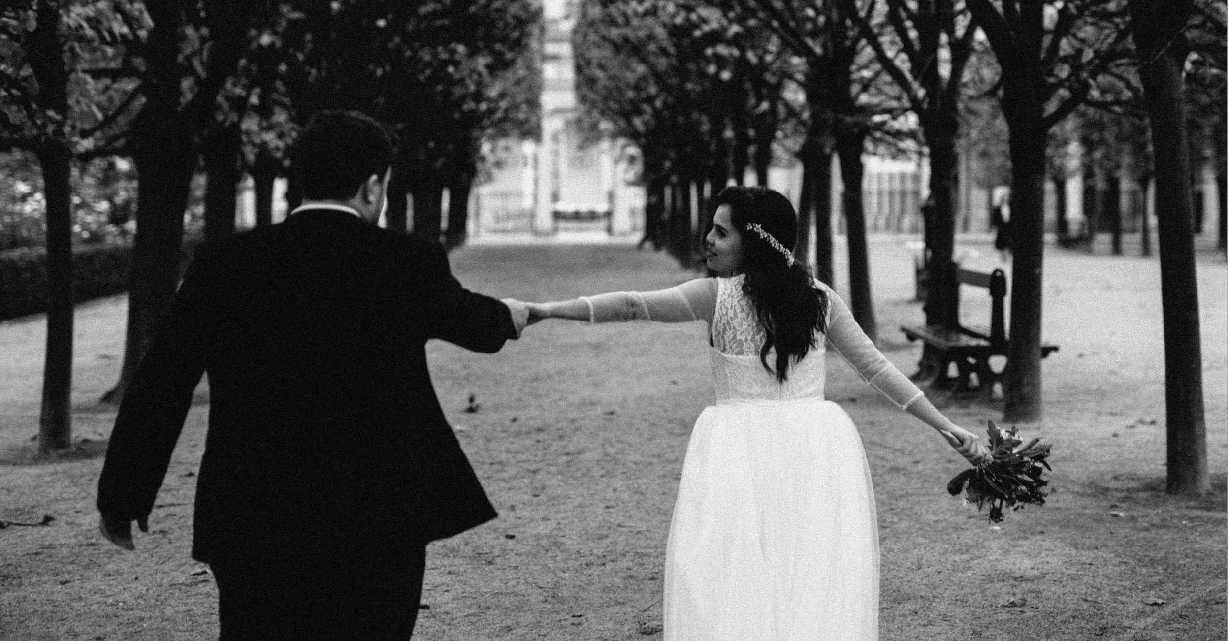 Wedding photo in Paris of a bride holding her bouquet and her groom by the hand