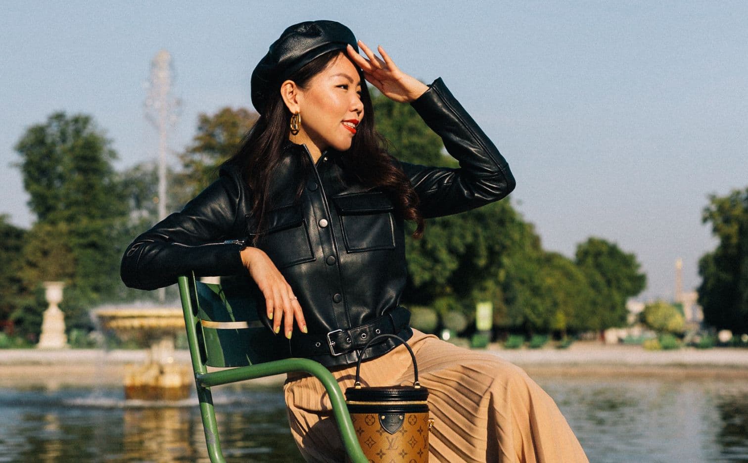Elegant woman in beret posing in Tuileries garden, Parisian chic portrait with Ferris wheel backdrop, fashion photography