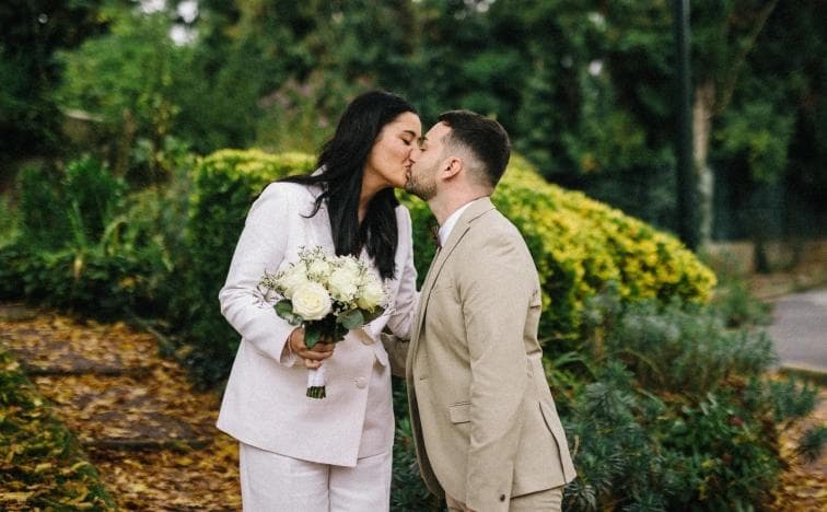 The bride and groom kiss in a beautiful forest